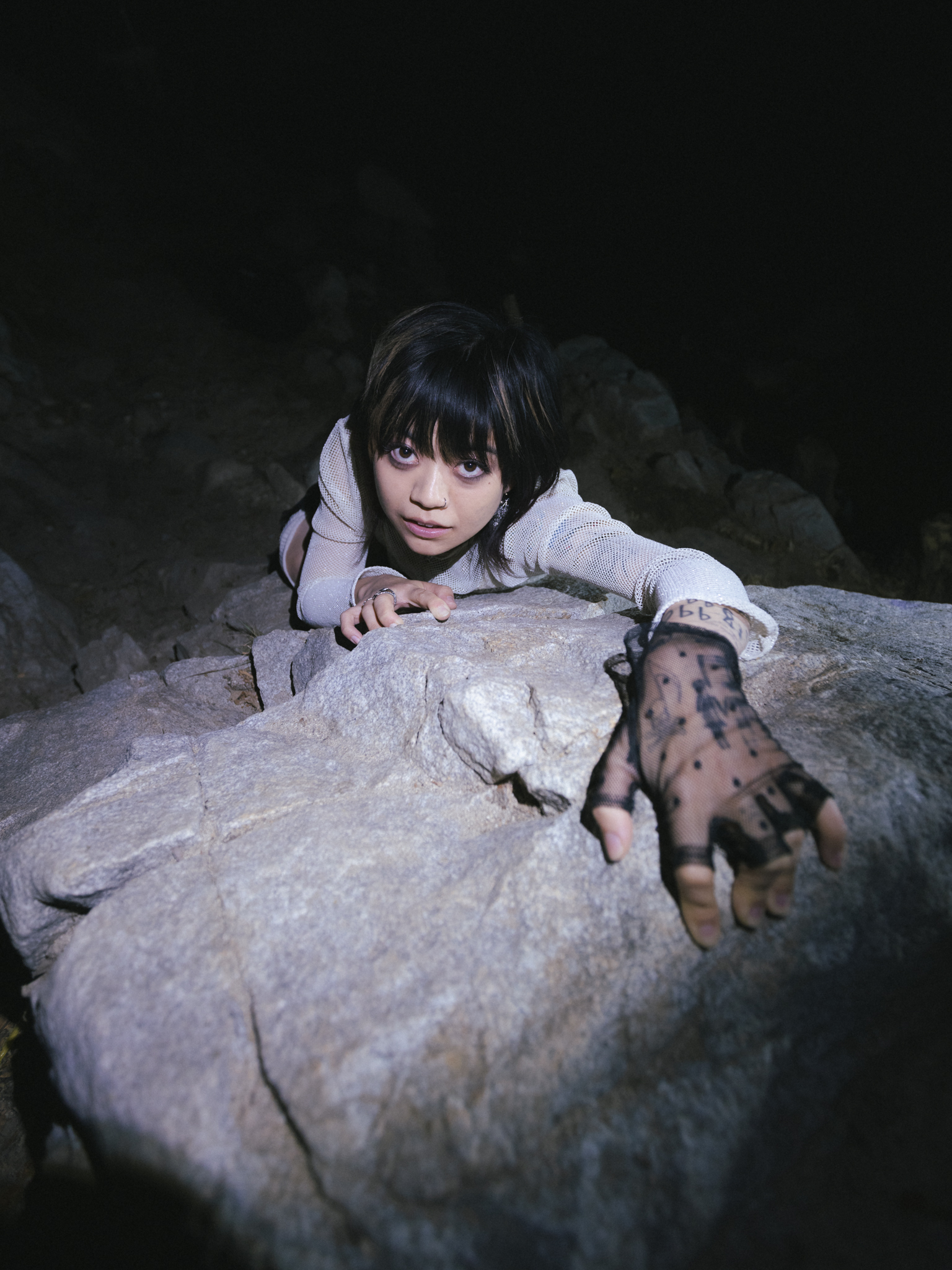 y.a.n. reaching across a rock face at night